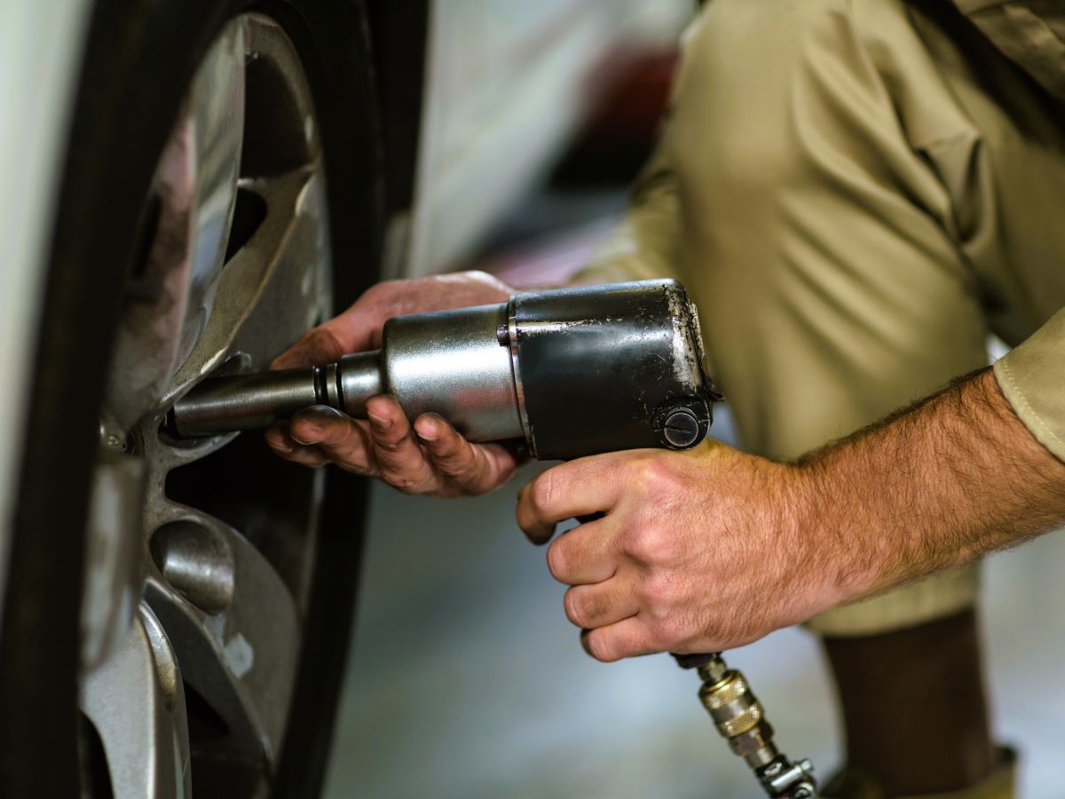 mechanic-fixing-car-wheel-with-pneumatic-wrench